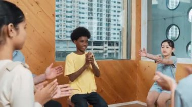 Çok kültürlü insanlar grup terapisinde cesaretlendirmek için el çırpıyorlar. Kafkas öğretmeni çocuklara bakarken çeşitli öğrencilerin el çırpışları kutlu olsun. Yaratıcı aktivite konsepti. Öğretim