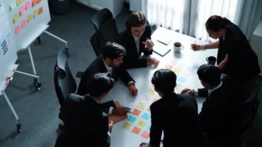 İş adamlarının toplantı odasında pazarlama stratejisi planlarken yapışkan notlar kullanarak beyin fırtınası yapma fikrine en iyi bakış açısı. Çeşitli takımlar mali planı tartışıyor. Takım çalışması konsepti. Müdürlük.