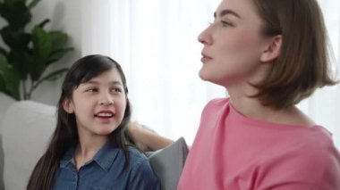 Mutlu anne oturma odasında otururken kızıyla deneyim paylaşıyor. Kafkas anne ve mutlu çocuk konuşuyorlar ve birlikte vakit geçiriyorlar. Çekici kız gülümserken ebeveyn hikayesini dinler. Pedagoji.