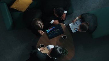Tabletten mali grafiğe bakarken pazarlama stratejisini planlamak için birlikte çalışan iş adamlarının en tepeden aşağı hava görüşü. Bir grup yetenekli insan beyin fırtınası yaratıcı bir fikir. Müdürlük.
