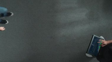 Yöneticinin elinde tablet tutarken yatırımcıya yürümesi ve mali istatistiklere bakması. Lider tabletteki hisse senedi piyasasının artması hakkında bilgi veriyor. Cemaat.