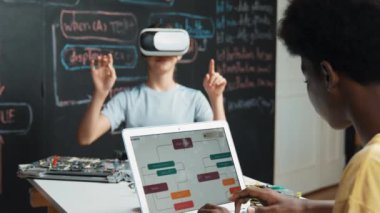 Afrikalı erkek programlama sistemi, beyaz bir kız karatahtanın başında mühendislik kodlarıyla otururken metaverse 'e giriyor. Liseli kız STEM teknolojisinde VR ya da kulaklık takıyor. Öğretim