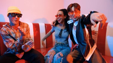 Mutlu kız kameraya bakıyor ve kanepede otururken pop müzik dinliyor. İspanyol kadın serbest stil dans ederken kameraya bakıyor neon ışıkta çeşitli arkadaşlarla dans ediyor. Mutluluk.