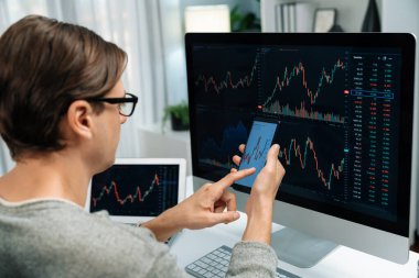 Akıllı borsa yatırımcıları ekranda akıllı telefon ile piyasa borsasını işaret ederek dizüstü bilgisayarın yanı sıra en yüksek dinamik yatırım oranını göstererek, modern işyerindeki veri planlamasına odaklanıyorlar. Bireysel.