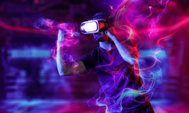 Neon boks sahasında kamera kıran ya da yumruklayan bir adam. Dijital teknoloji yeniliklerini kullanırken sporcu boks ve metaevren veya sanal dünyada hareketli jest. Sapma.