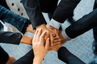 Birçok mutlu iş adamı neşe ve başarıyla el ele tutuşuyor. Şirket çalışanı başarılı bir iş projesini bitirdikten sonra kutlama yapıyor. Şirket ortaklığı ve başarı kavramı. uds