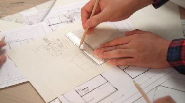 Mimari ekipmanlarla toplantı masasında ev tasarımı üzerine profesyonel mühendis ekibi tartışması ve modern ofiste bina planı dağılımı. Eline odaklan. - Yakın çekim. Tanımlama.