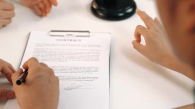Ayrıldıktan sonra mülkleri bölüşmek için hukuk firmasının yardımıyla boşanma davası açan çiftler. Anlaşma görüşmesinde avukatın yükümlülükler sözleşmesi yardımı. Ağır çekim. Katı.