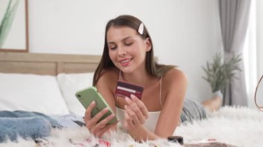 Genç bir kadın kredi kartıyla ödemek için internet üzerinden ödeme uygulaması ve dijital cüzdan kullanıyor. Mobil internet üzerinden alışveriş ve modern alımlar. Düzenle