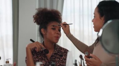 İki kadın nüfuzlu kişi canlı yayında video görüntülerini çekiyor. Makyaj çok önemli sosyal medya veya blog. Kozmetik stüdyosu ışıklandırmalı mutlu genç kız çevrimiçi pazarlama oturumu yayını için..