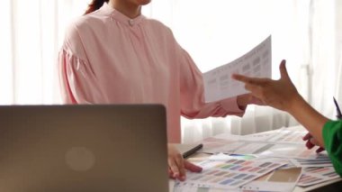 Yavaş çekim iki tasarımcı beyin fırtınası yapıyor ve grafik tasarımı için renk seçiyor ya da istemci renk bozukluklarını tasarımcı bürosundaki kromatik konsültasyonla karşılaştırıyor. Değiştirilmiş