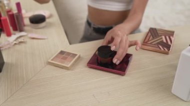 Sosyal medya için güzellik ve kozmetik video içeriği hazırlayan genç bir kadın. Güzellik blogcusu kameraya gülümserken seyircilere ve takipçilere güzellik bakımını gösteriyor. Düzenle