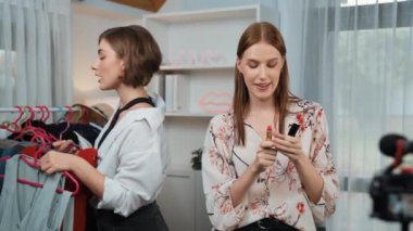 İki kadın nüfuzlu kişi canlı yayın yapan video klip eleştirisi kıyafetlerini sosyal medyada ya da blogda yayınlıyor. Stüdyo ışıklandırmalı mutlu genç kız çevrimiçi pazarlama oturumu yayını için..