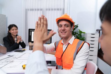 Çeşitli inşaat mühendisi ve müvekkil grupları, mimari proje üzerinde başarılı bir anlaşma yaptıktan, inşaat planını gözden geçirdikten ve toplantı masasında plan oluşturduktan sonra kutlama ve beşlik çakışma yaptılar.