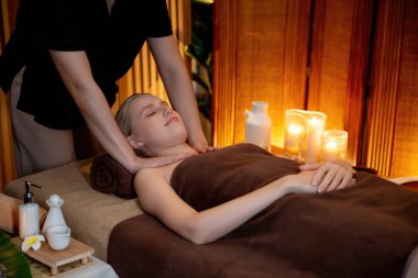 Beyaz kadın müşteri stres önleyici spa masajının keyfini çıkarıyor ve lüks otel ya da otelde sıcak mum ışığında güzellik teniyle eğleniyor. Sessiz.