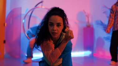 Çekici mutlu dansçı kameraya bakarken zeki kadın neon ışıkla kafiyeli hareket ediyor. Profesyonel İspanyol şarkıcı çeşitli arkadaşlarıyla renkli kıyafetler giyerken break dans yapıyor. Mutluluk.