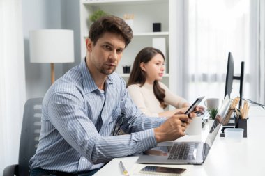 Ofis çalışanı akıllı adam tablet ve kalem kullanarak fotoğraf çekme işine bakıyor. Modern ofis saatlerinde güzel bir iş arkadaşıyla poz vermek için kalem kullanıyor. Varsayım.