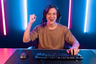 Kazanmak için çevrimiçi oyun oynayan akıllı flama makinesinin sunucu kanalı, neon ışıklı odada seçilen takım yarışması için izleyicilerle birlikte canlı yayında canlı yayında kulaklık takıyor. Bireysel.