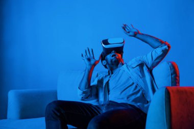 Kanepede otururken VR gözlüğü takıp korku filmi izleyen korkmuş bir insan. Kafkasyalı bir adam sanal gerçeklik simülasyonu kullanarak korku oyunları oynuyor. Sapma.