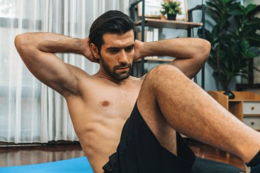Atletik ve sporcu adam, evde vücut egzersizi yaparken spor ve spor yaşam tarzına uyum sağlamak için spor minderinde çatırdıyor. Gaiety ev egzersizi antrenman konsepti.
