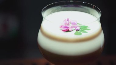 Tutkulu meyve suyu bardağında dönüşümlü, özel, ferahlatıcı, pembe çiçekle süslenmiş, lüks gece klübünde gece hayatı karışımı sergilenen bir içecek. Vinosity.