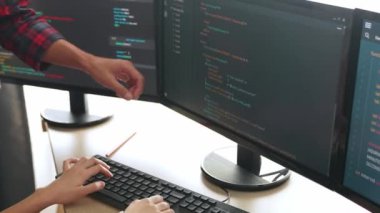 Yavaş çekimde geri uç veya yazılım geliştirici yöneticisi ekibini monitörde hata ayıklama ve karmaşık kod algoritmalarını çözmede yeni uygulama programı geliştirmede denetliyor. Filizlenen