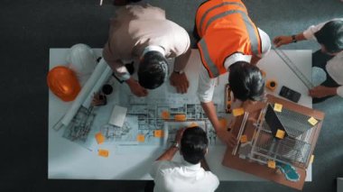 Becerikli mühendis ekibinin ev inşaatından bahsedişinin en alt görüntüsü. Mimar ya da tasarımcı grubunun planlar hakkında beyin fırtınası yapmak için tartışan ve yazan hava görüşü. Hizalama.