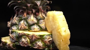 Taze ananas kesiminin makrografisi, parlak siyah bir arka planda ortaya çıkıyor. Her yakın çekim ananasın karmaşık detaylarını ve dokularını yakalar. Kapatın. Geliştirilebilir.