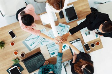 İş adamları ve iş kadınları, takım çalışması, destek ve iş birliğini gösteren çok kültürlü ofis odasındaki grup toplantılarında el ele tutuşuyorlar. Çeşitli işyerleri ve şirket çalışanları konsepti. uds