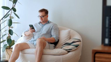 Orta yaşlı bir adam, iş için telefon arama verilerini kullanarak, çocukları iyi bir yetişkin ya da eğlence olsun diye odada kahve fincanıyla koltukta oturur. İşadamı teknolojiyi kolaylık için kullanır. Uyumsuzluk.