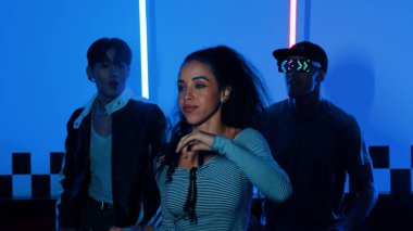 Gündelik gömlekli, gözlüklü, neon ışıkla dans eden farklı insanlar. Gece kulübünde dans ederken kameraya bakıp sokak dansı yapan çok kültürlü break dansçı. Mutluluk.