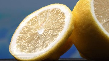 A slice of lemon, bright yellow and vibrantly citric, lies exposed. The yellow flesh, with refreshing juice, reveals its segmented interior. The essence of citrus vibrancy. Slow motion. Comestible. clipart