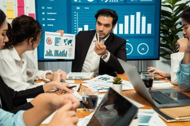 Finansal veri raporunu analiz eden çeşitli bir grup iş analisti. Mali veri analiz çizelgesi ve grafik paneli stratejik pazarlama planlama için toplantı odasında TV ekranında. Habiliment