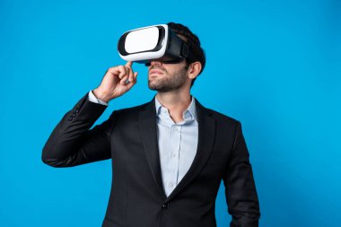 Kafkasyalı iş adamı, sanal gerçeklik gözlüğü kullanırken finansal plan yapıyor. Görsel gerçeklik gözlüğü kullanarak metaevreni bağlarken profesyonel proje yöneticisi ayakta ve VR kulaklığına dokunuyor. Sapma.