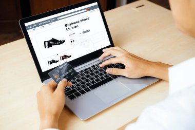 Genç adam, laptop bilgisayar başvurusu ya da web sitesinde online alışveriş yapmak için kredi kartı kullanıyor. E-ticaret ve online alışveriş konsepti. uds
