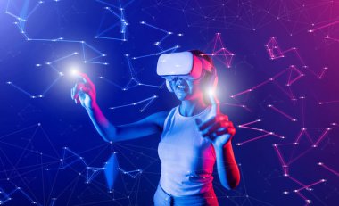 Siberpunk neon ışığı altında duran kadın beyaz VR kulaklık takıyor ve metaevreleri birbirine bağlayan kolsuz tişört, gelecekteki siber uzay topluluğu teknolojisi, iki parmağıyla sanal gerçeklik objesi kullanıyor. Halüsinasyon.