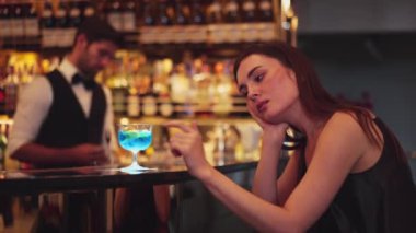 Oturan güzel bayan misafirin canı sıkılıyor. Arkadaşlarını beklemekten ya da barmenlerin arka planındaki lüks tezgah barında karışık votka içmekten sıkılıyor. Vinosity.