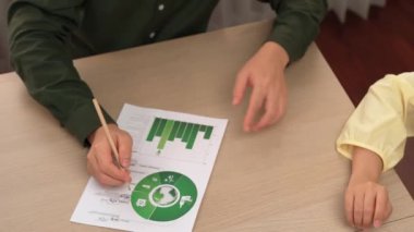 Mükemmel iş adamları, karbon ayak izini azaltmak, Dünya 'yı kurtarmak için grafik, yel değirmeni, ev ve ağaç modelini kullanarak yeşil enerjili eko ev projesinde işbirliği yaparlar. Eline odaklan. Tanımlama.