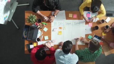 İş adamlarının yukarıdan görünüşü toplantı odasında kargaşa yaratıyor. Kanban yönetim kurulunun iş akışını yönetmesi için kağıt ve yapışkan notlar yazan bir grup insan. Zaman aşımı. Cemaat.