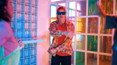 Kafkas dansçısı dans ederken çeşitli arkadaşları gece kulübünde neon ışıkta ayak seslerine bakıyor. Çoklu etnik kökenli hipsterin serbest stil müziğe geçişi ve mutlu bir adamın kameraya bakışıyla. Mutluluk.