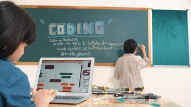 Kız, yazılım geliştirme planı yazarken yapay zeka yazılımı ya da programlama sistemini kullanarak kök sınıftaki elektronik ana tahtada yapay zeka üretiyor. Pedagoji.