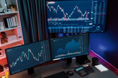 Dinamik borsa grafiklerinin büyük ekranları neon ışıklı gece vakti bilgisayarda görünüyor. Finansal teknolojiye yapılan güncellenmiş yatırımla otomatik olarak satış ya da kâr satın alma. İnfobahn.