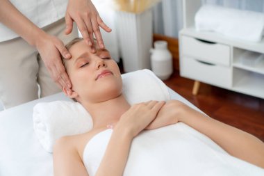Kafkasyalı kadın stres önleyici kafa masajından ve lüks tatil beldesi ya da otel spa salonundaki modern ışık ortamında yüz güzelliği eğlencelerini şımartmaktan hoşlanıyor. Sessiz.