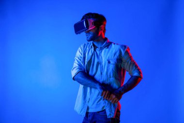 Kafkasyalı bir adam VR cam takıyor ve hareket eden el kol kılıcını tutuyor. Oyuncu, gelecekteki sanal gerçeklik kulaklığını ya da gelecekteki yenilikleri kullanarak meta dünyaya giriyor ya da aksiyon oyunu oynuyor. Sapma.