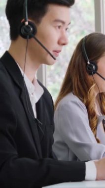 Ofiste çalışan kulaklık takan işadamları uzak müşteri ya da meslektaşlarını desteklemek için çalışıyorlar. Arama merkezi, tele pazarlama, müşteri destek acentesi telefon görüşmesinde hizmet sunar.