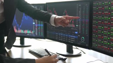 Hisse senedi borsası pazarlamasını analiz eden yavaş çekim şirketindeki yatırımcılar, kayıp için mum bar fiyatını analiz eden monitörlere bakıyor ve kazanç ve kâr elde ediyor. Filizlenen