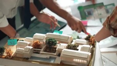 Akıllı iş adamlarının tasarımı planlamak için tabletten proje planına bakarken ve planlar ve toplantı masasındaki bina inşaatı hakkında tartışırken birlikte çalışması. Hizalama.