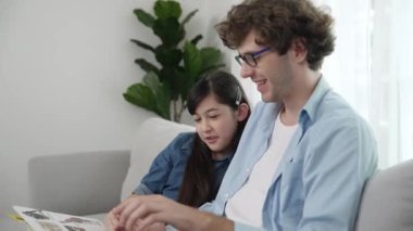 Beyaz bir baba ve tatlı bir kız kanepede otururken masal kitabı okuyorlar. Mutlu bir baba, sevimli bir Amerikan çocuğuna, birlikte zaman geçirirken hayal gücünün gelişmesi için hikaye anlatıyor. Pedagoji.