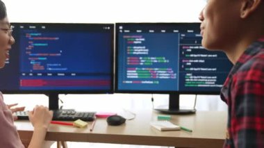 Yavaş çekim arkası yazılım geliştirici mühendisi bilgisayar programlama için birlikte çalışarak hata ayıklama kodunu çözüyor, ofiste monitörde karmaşık algoritmaları çözüyor. Filizlenen