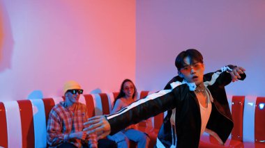 Asyalı bir adam pop müzikle dans ederken, çok kültürlü bir arkadaş evde ışık altında oturuyor. Çekici bir sokak dansçısı kameraya bakarken hip hop müzik dinliyor. Mutluluk.